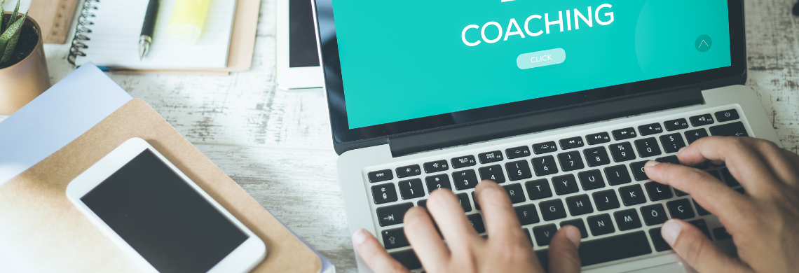 Man sieht einen Laptop, auf dessen Bildschirm "Coaching" steht.